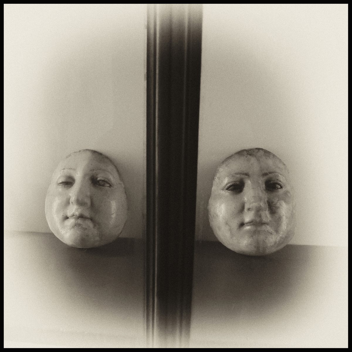 Two pale human faces separated by dark vertical lines in Armageddon by Augusto De Luca