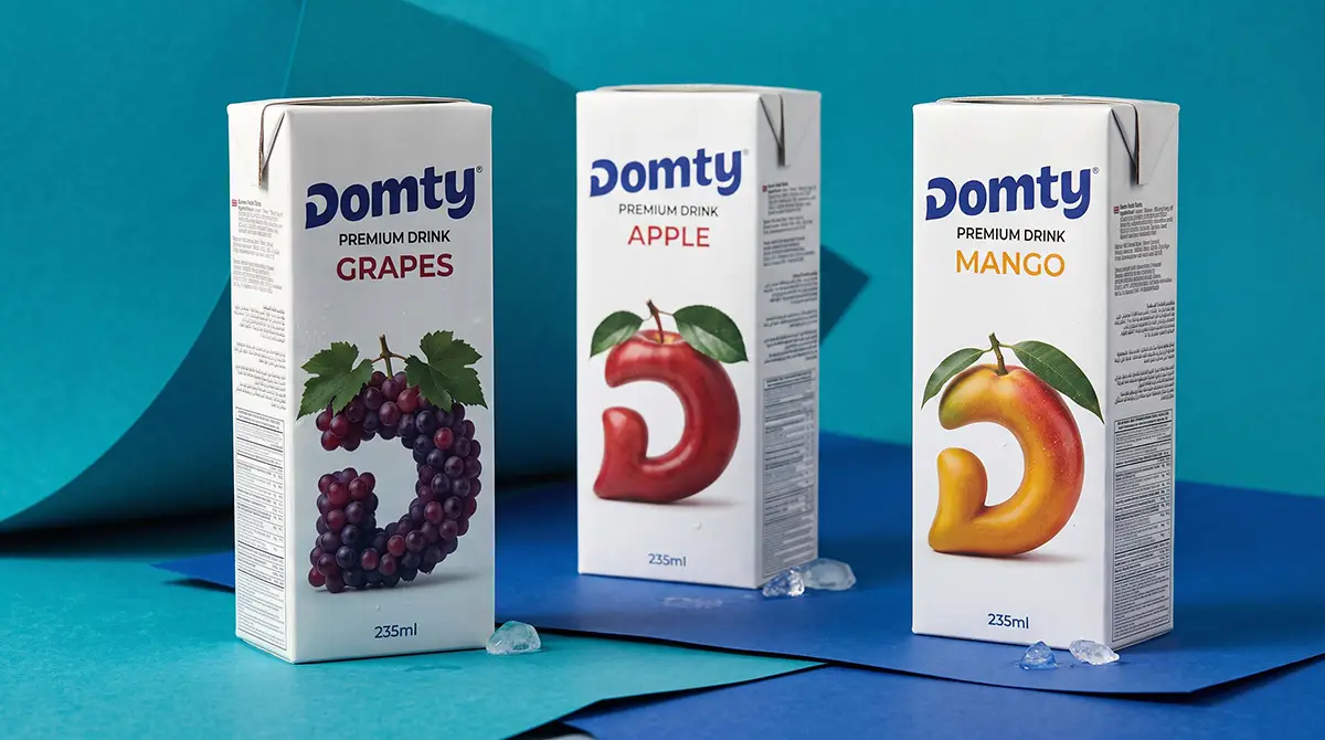 DOMTY juice carton packaging featuring grape, apple and mango flavours against a blue backdrop